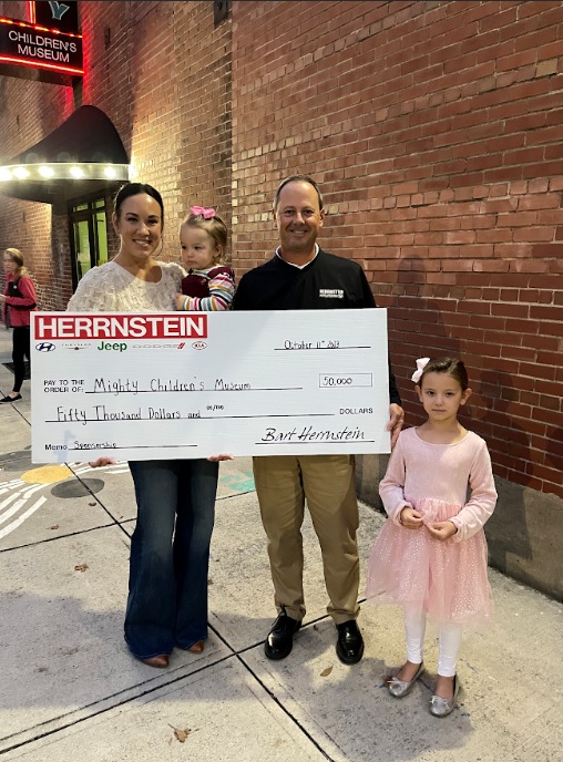 The Herrnstein family presenting a $50,000 donation check to the Mighty Children's Museum.